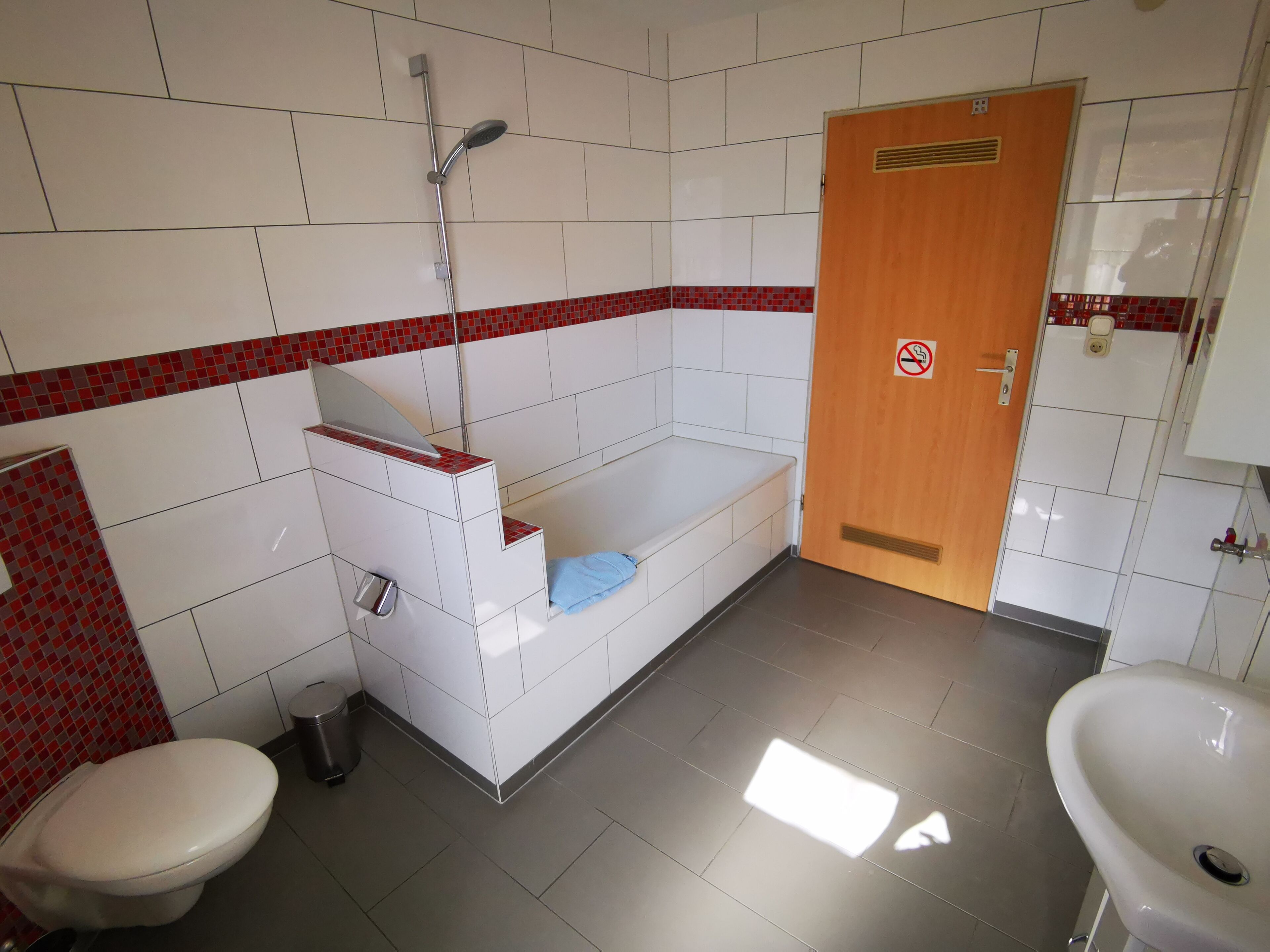 A bathroom with a toilet, sink, and shower.