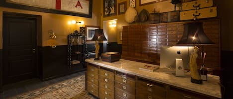 A room with a wooden cabinet, a desk with a computer, and a flag on the wall.