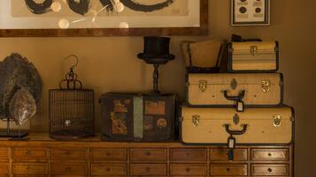 Une commode en bois avec de nombreux tiroirs et une pile de valises anciennes.