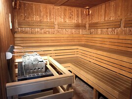 Una sauna con bancos de madera y suelo de piedra.