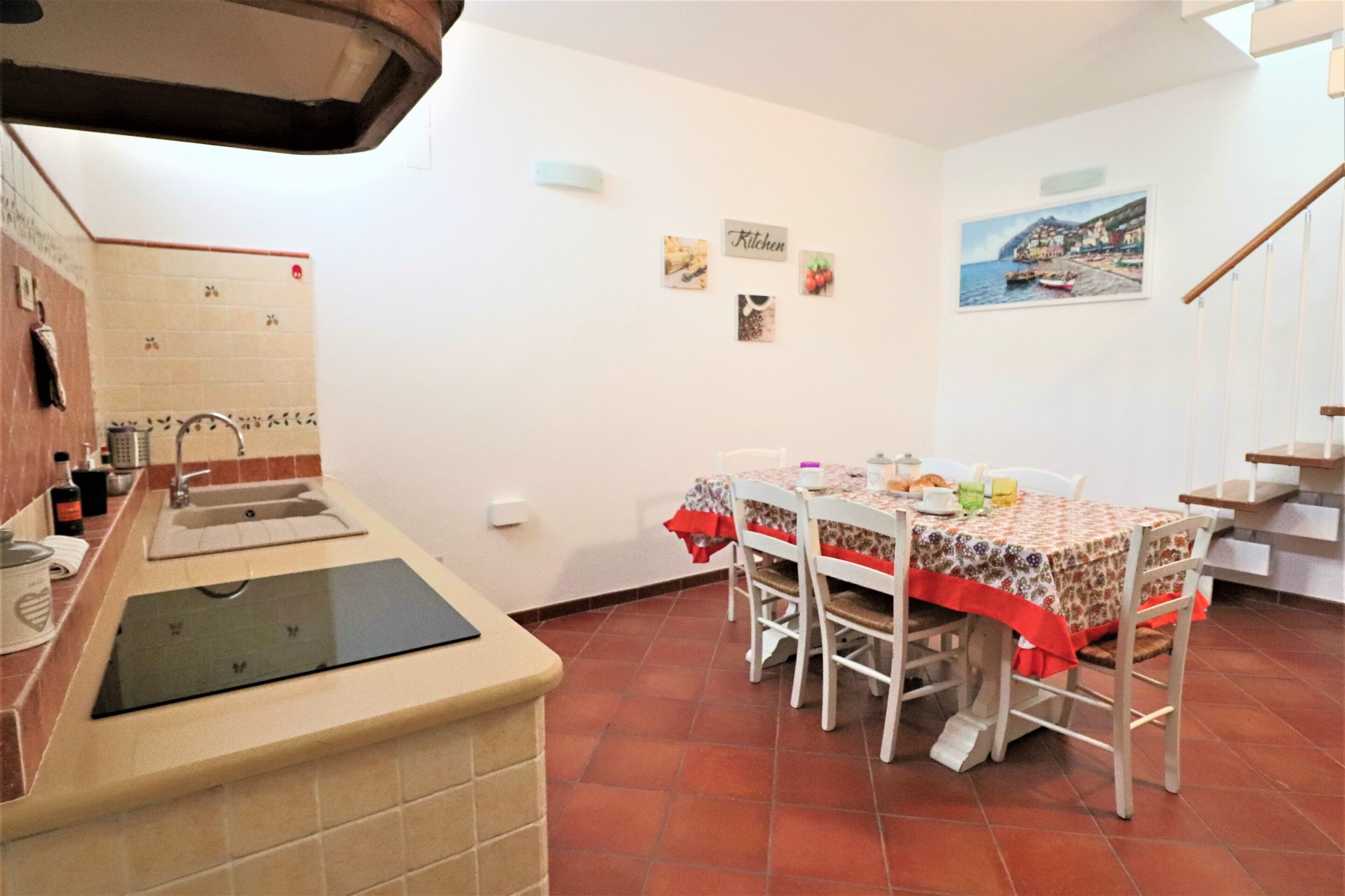 Une cuisine équipée d’un évier, d’une cuisinière et d’une table à manger avec des chaises.