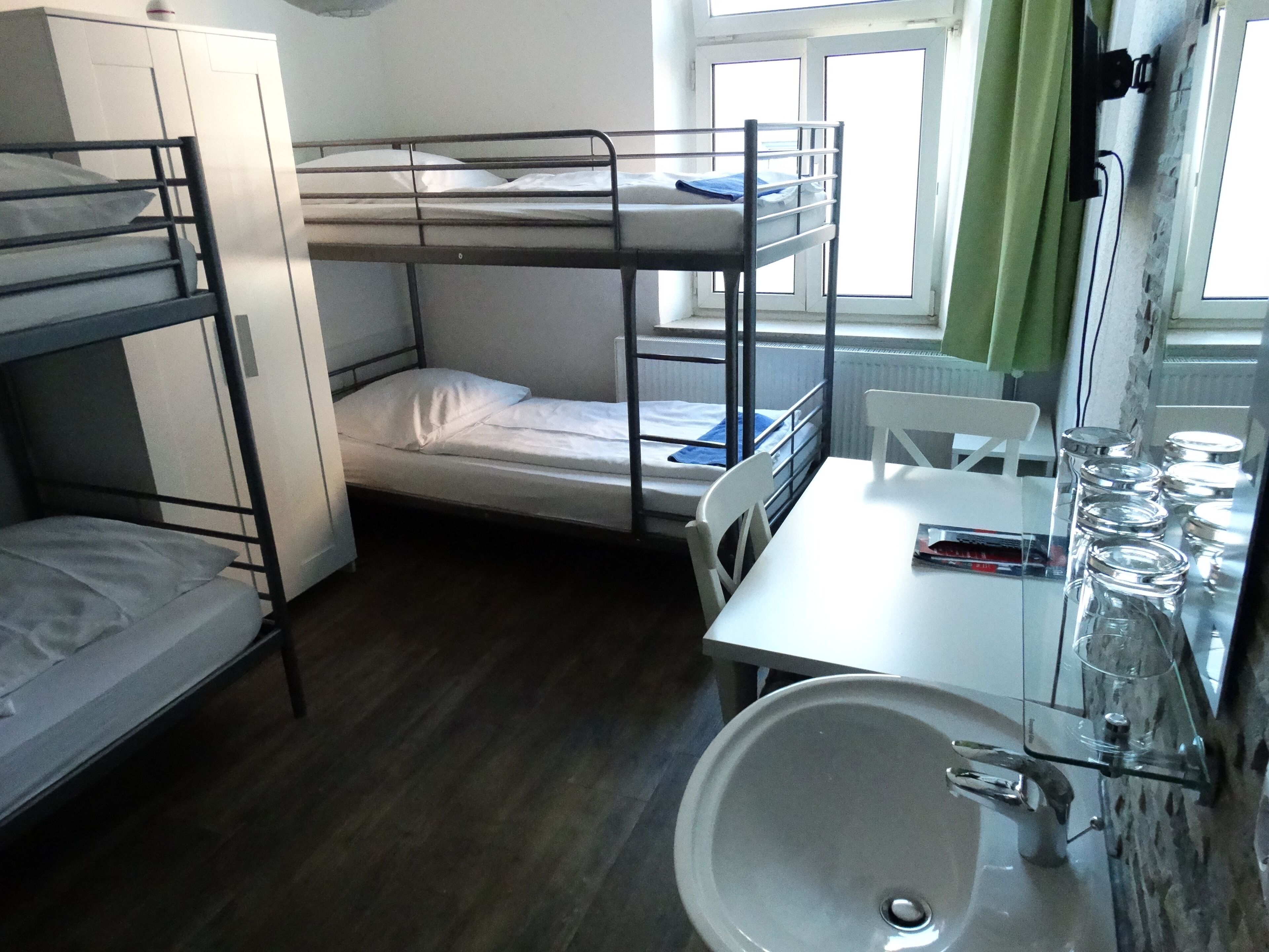Habitación con literas, un lavamanos y una mesa.