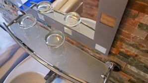 A bathroom with a sink, mirror, and a bed with a blue towel. - City Hostel (Augsburg)