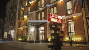 Ett hotell med en modern fasad, en framträdande entré med en trappa och en skylt som visar att det är ett hotell.