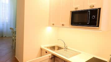 Apartamento, 1 quarto, cozinha, ao lado da praia | Cozinha americana privada | Geladeira, micro-ondas, cooktop, cafeteira/chaleira