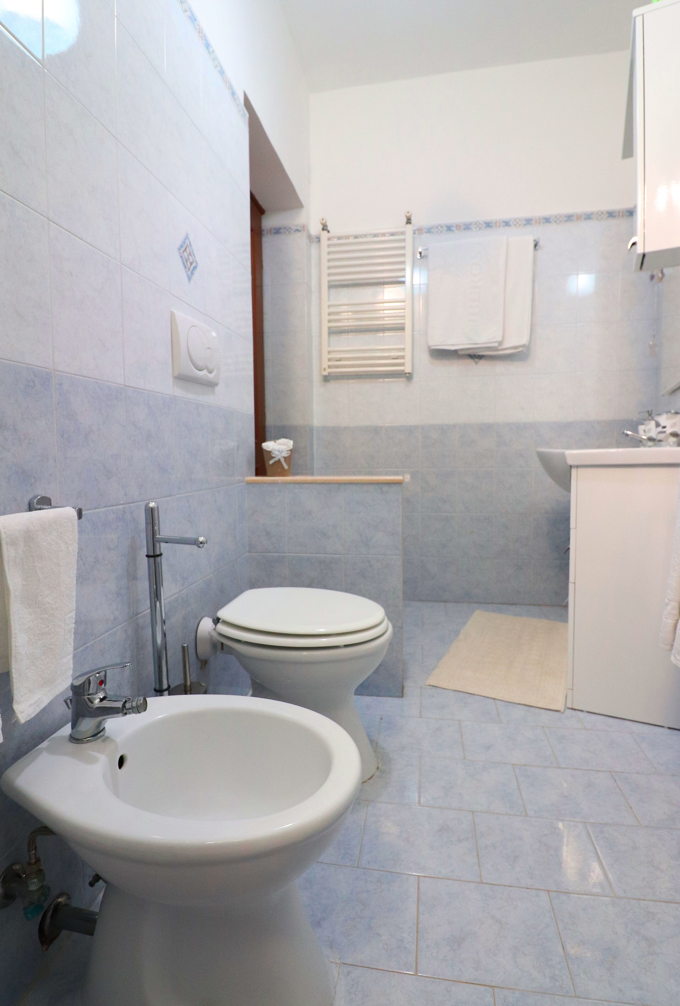 Een badkamer met toilet, bidet en wastafel.