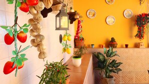 Una cucina con piante sospese, un lanterna e piatti decorativi appesi al muro.
