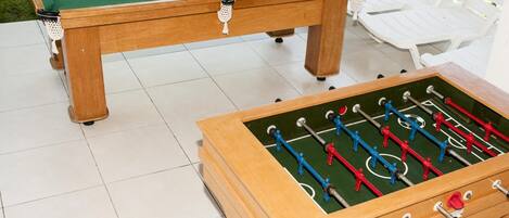 Une table de billard avec une table de baby-foot placée devant.