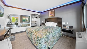 Een moderne hotelkamer met een groot bed, een bureau en een douche.