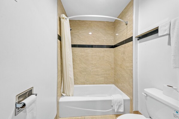 A modern bathroom with a shower, bathtub, toilet, and towel rack. - Starlight Inn South El Monte (South el Monte)