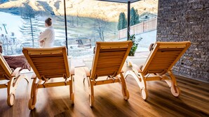 A room with wooden chairs facing a large window overlooking a snowy landscape. - Wellness- und Genußhotel Rosmarie (Moso in Passiria)