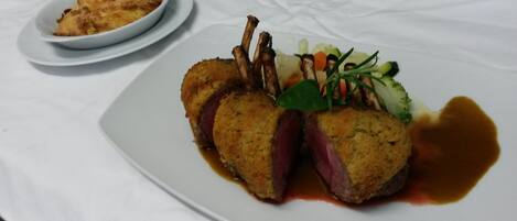 Un plato con carne, verduras y salsa.