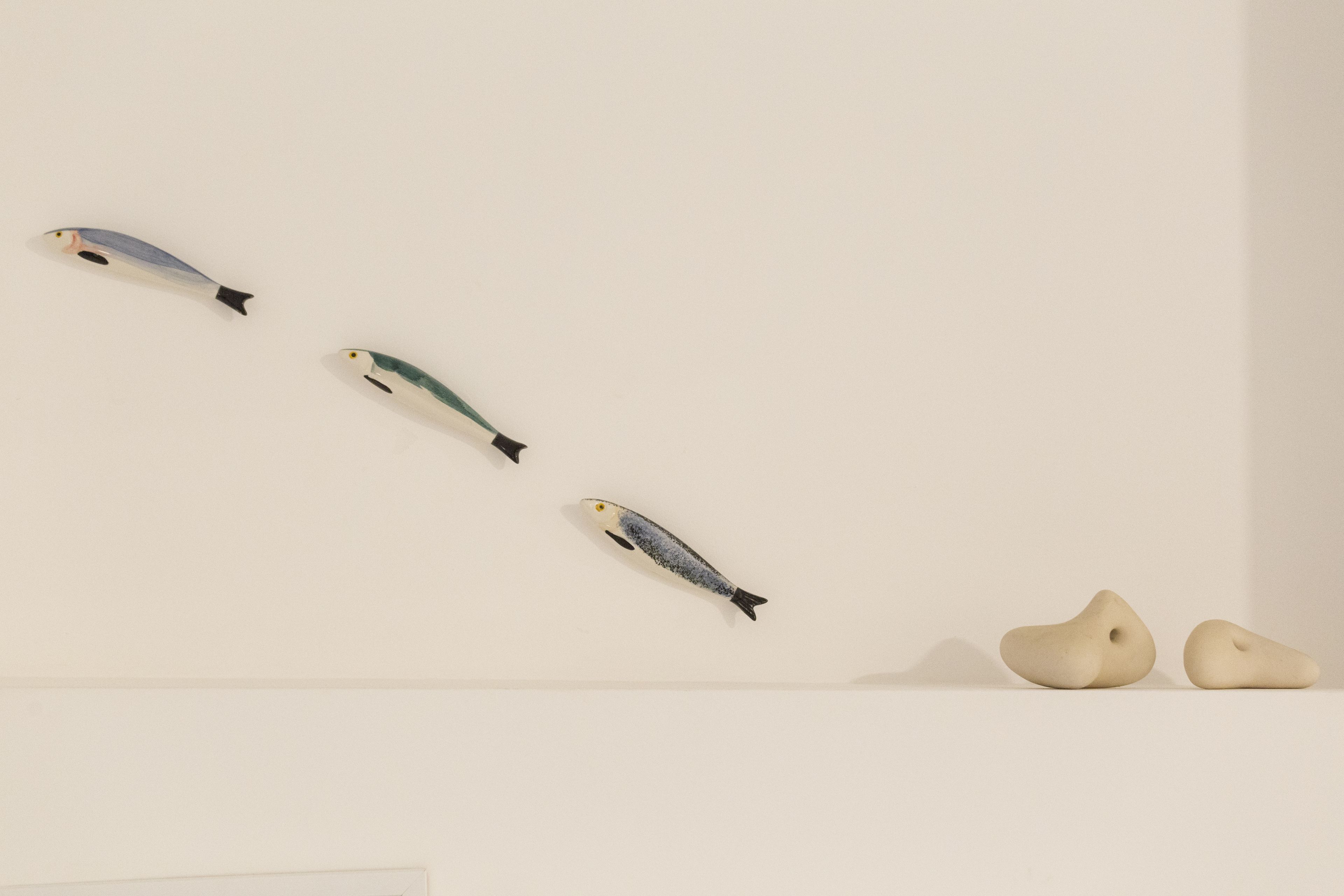 A wall with four fish-shaped objects and two abstract shapes.