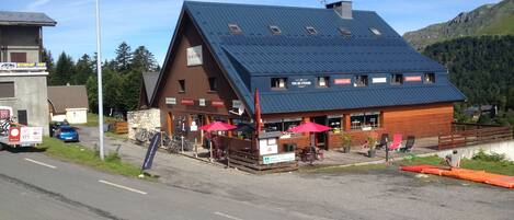 Et fjeldhotel med restaurant og bar, udendørs siddepladser samt en skiftekke i nærheden.