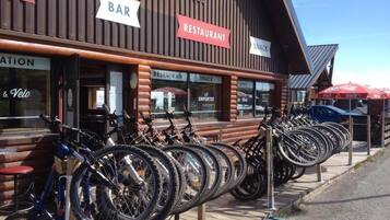 A restaurant with a bar and a snack area, featuring a row of bicycles parked outside.