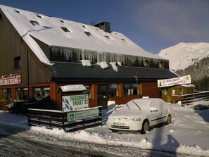 A building with a snow-covered roof and a sign for 'Randononnees Raquettes'. - Le Tuc de l'Etang (Boutx)