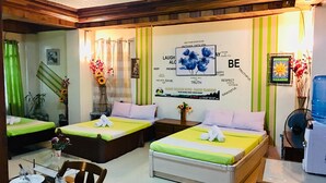 Une chambre d’hôtel avec deux lits, une table à manger et un distributeur d’eau.
