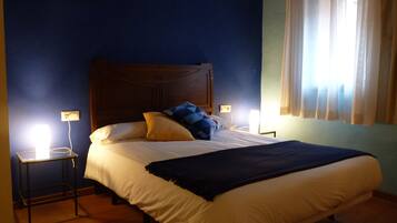 A bedroom with a large bed, two bedside tables, and a window with curtains.