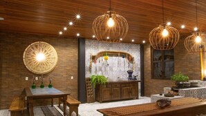 A modern kitchen with wooden cabinetry, a marble backsplash, and pendant lighting. - Pousada Armazem 26 (Tiradentes)