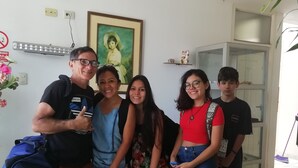 A group of five people posing in a room with a couch, a framed portrait, and a shelf with decorative items. - Hospedaje Harjeny (Trujillo)