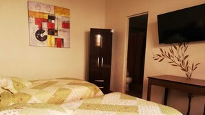 A room with a bed, a wardrobe, a television, and a wall decoration. - Gran Hotel (Arequipa)