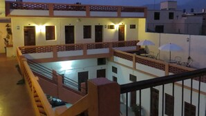 A courtyard with a pool, a covered seating area, and a staircase leading to an upper level. - Gran Hotel (Arequipa)