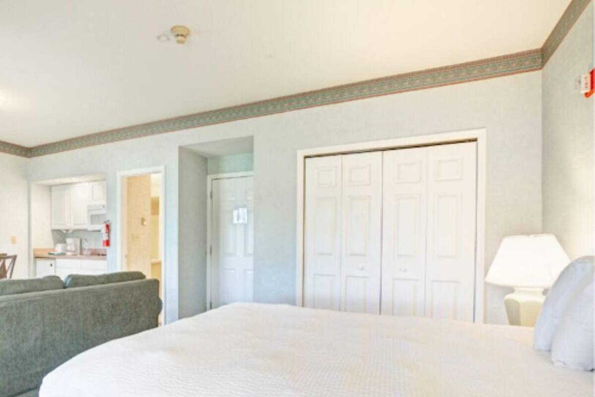 Une chambre d’hôtel avec un grand lit, un canapé, un bureau et une armoire.