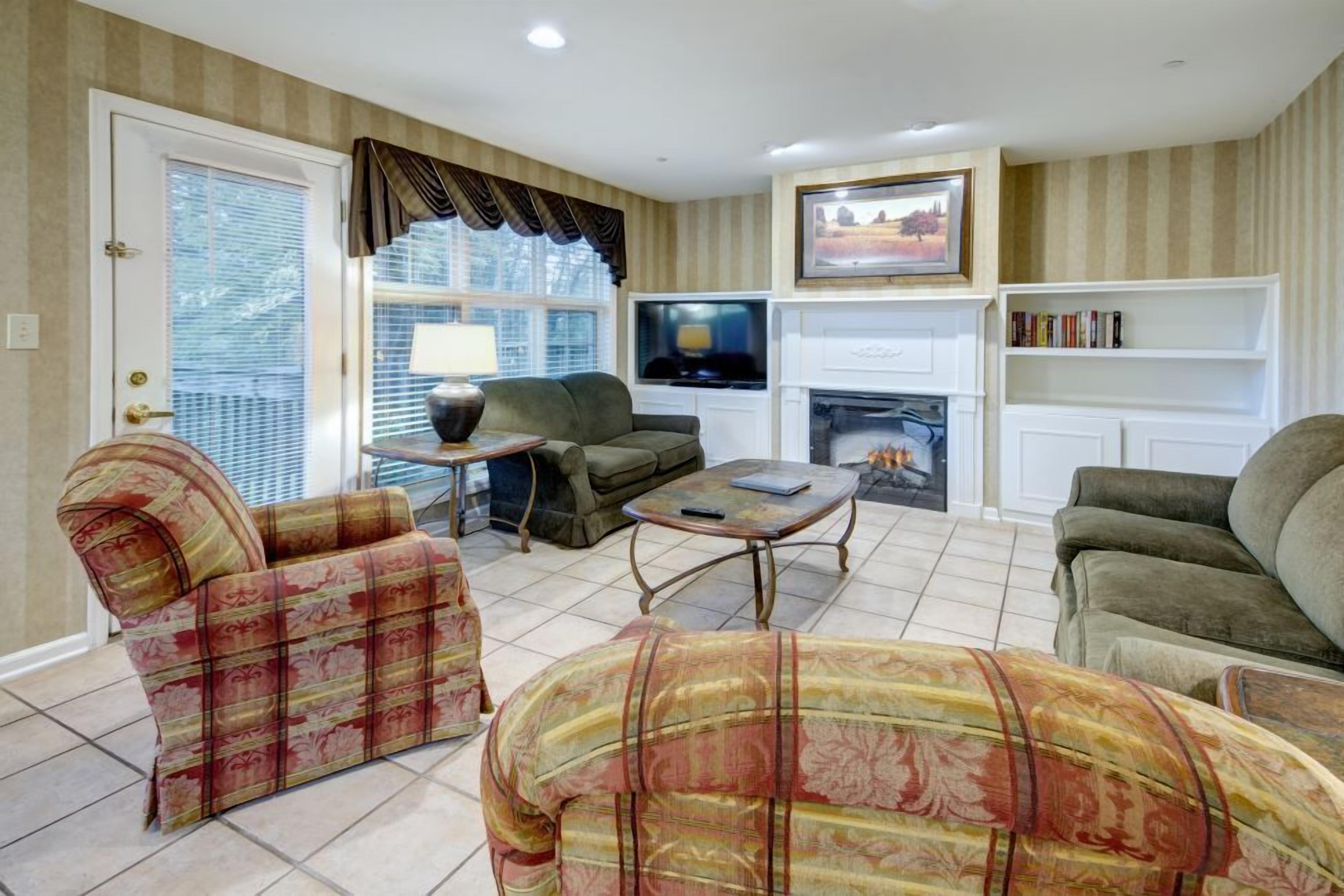 A living room with a fireplace, a television, and a bookshelf.
