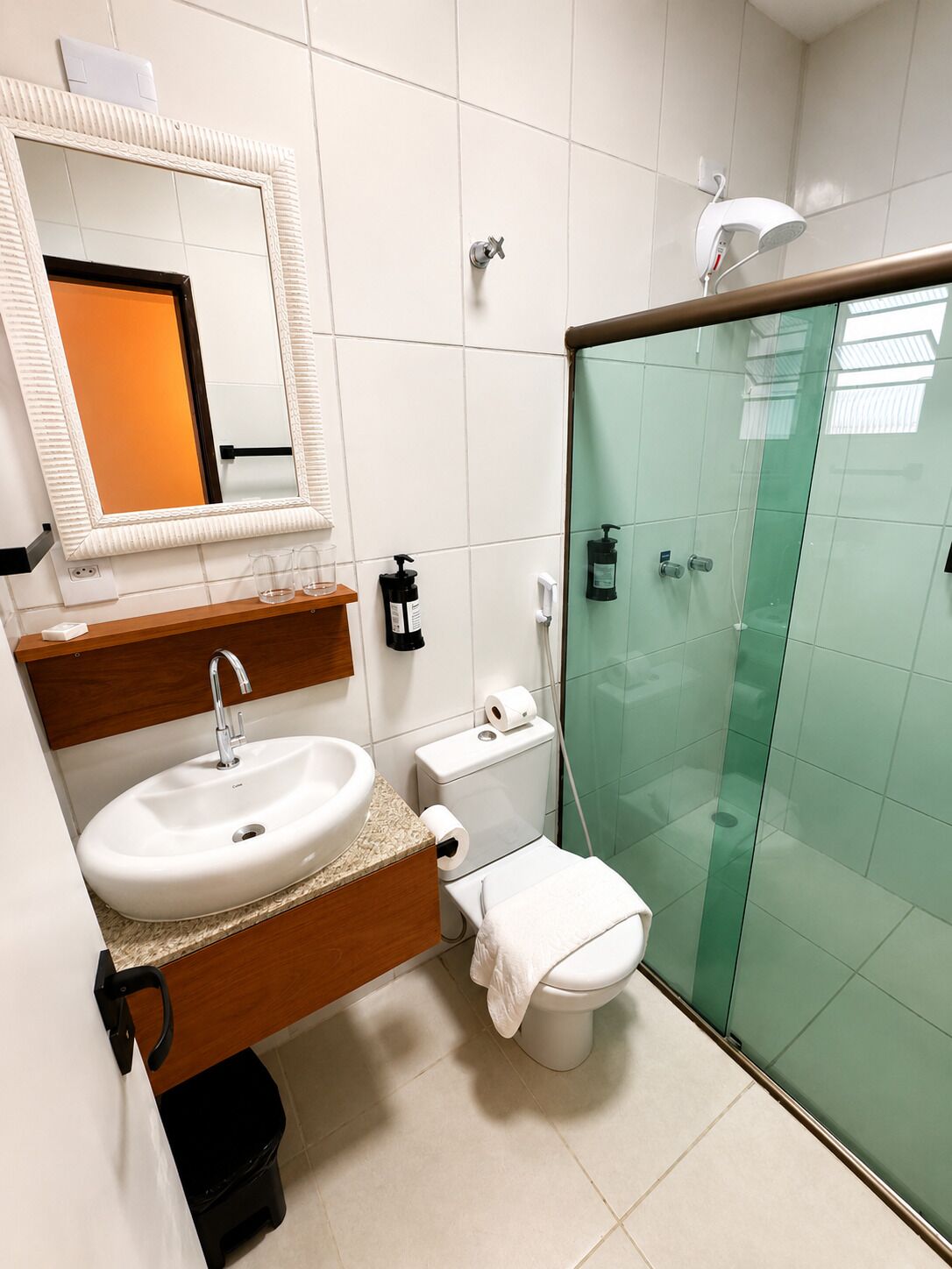 Uma casa de banho moderna com lavatório, sanita e cabine de duche em vidro.