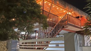 A building with a thatched roof and wooden railings, featuring a staircase leading to an upper level. - Boca Simon Vacation Curacao (Willemstad)