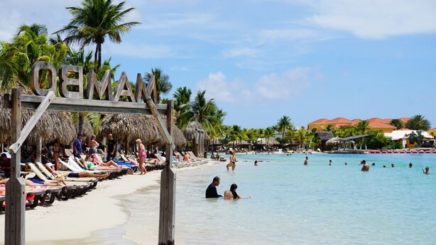 A beach with wooden lounge chairs and a sign that reads "OCEAN". - Boca Simon Vacation Curacao (Willemstad)