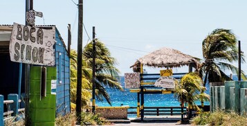 Una entrada frente a la playa con un letrero que dice "BOCA SIMON" y otro cartel dando la bienvenida a los visitantes a "Simon".