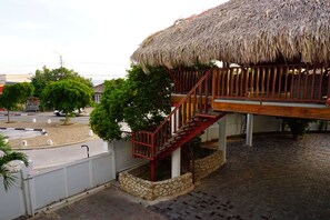 Un bâtiment doté d’un toit de chaume et d’un escalier en bois menant à un balcon.