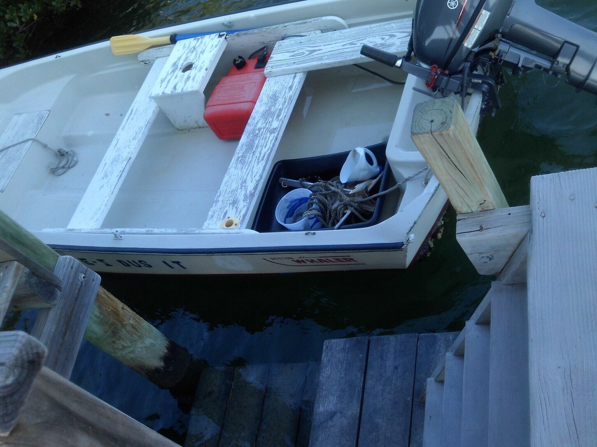A small boat docked at a wooden pier.