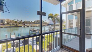 Ein Balkon mit Blick auf einen Yachthafen, einem Schild mit der Aufschrift 'BEACH' und blauem Himmel.
