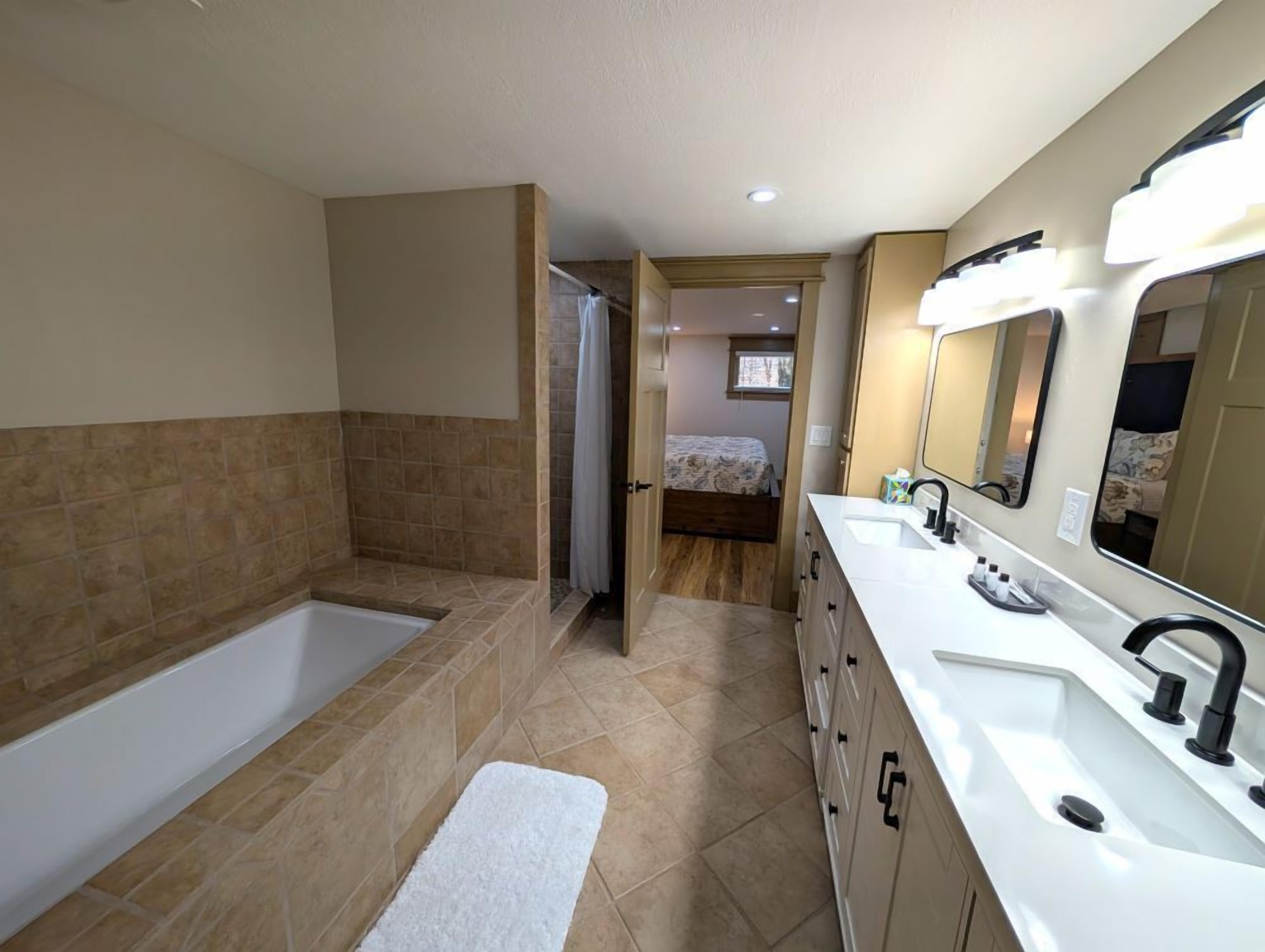 Un baño con bañera, lavamanos y ducha.