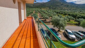A balcony with orange tiles, a green railing, and a view of olive trees and a mountain. - Rescator Resort 215 - One Bedroom Apartment, Sleeps 4 (Roses)