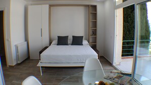 Ein modernes Schlafzimmer mit einem großen Bett, einem Glastisch und einer eingebauten Regaleinheit.
