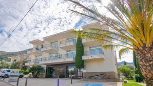 A multi-story building with a parking area, a handicap-accessible sign, and a sign for "Rescator". - Rescator Resort 210 - One Bedroom Apartment, Sleeps 4 (Roses)