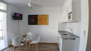 A modern kitchen with a dining area, a ceiling fan, and artwork on the wall. - Rescator Resort 229 - One Bedroom Apartment, Sleeps 4 (Roses)