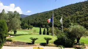 A golf course with flags, trees, and a mountainous background. - Villa for 6 People with Pool and Unobstructed View (LA LONDE LES MAURES)
