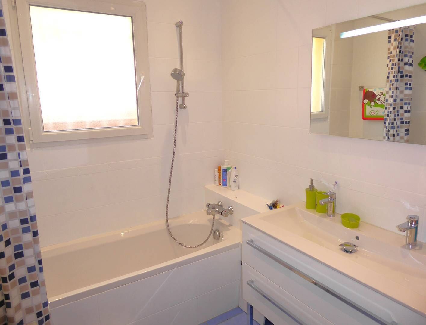 Ein Badezimmer mit Badewanne, Dusche, Waschbecken und Pflegeprodukten sowie einem Spiegel.