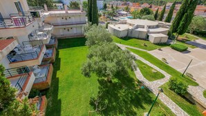 A courtyard with a swimming pool, surrounded by buildings with balconies and a mountainous backdrop. - Rescator Resort 205 - One Bedroom Apartment, Sleeps 4 (Roses)