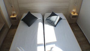 A double bed with two pillows, a nightstand with a lamp, and a wooden headboard. - Rescator Resort 225 - One Bedroom Apartment, Sleeps 4 (Roses)