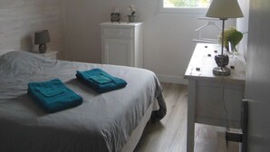 A bedroom with a bed, a bedside table, a lamp, and a window. - Pretty Cozy 3 * house, green 7/8 pers St Gildas de Rhuys, 1km bg, 2km beach (Saint-Gildas-De-Rhuys)