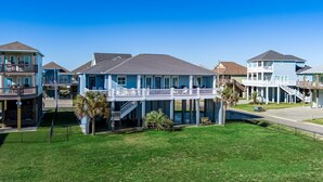 Una propiedad frente a la playa con casas de varios pisos, balcones y un paseo techado.