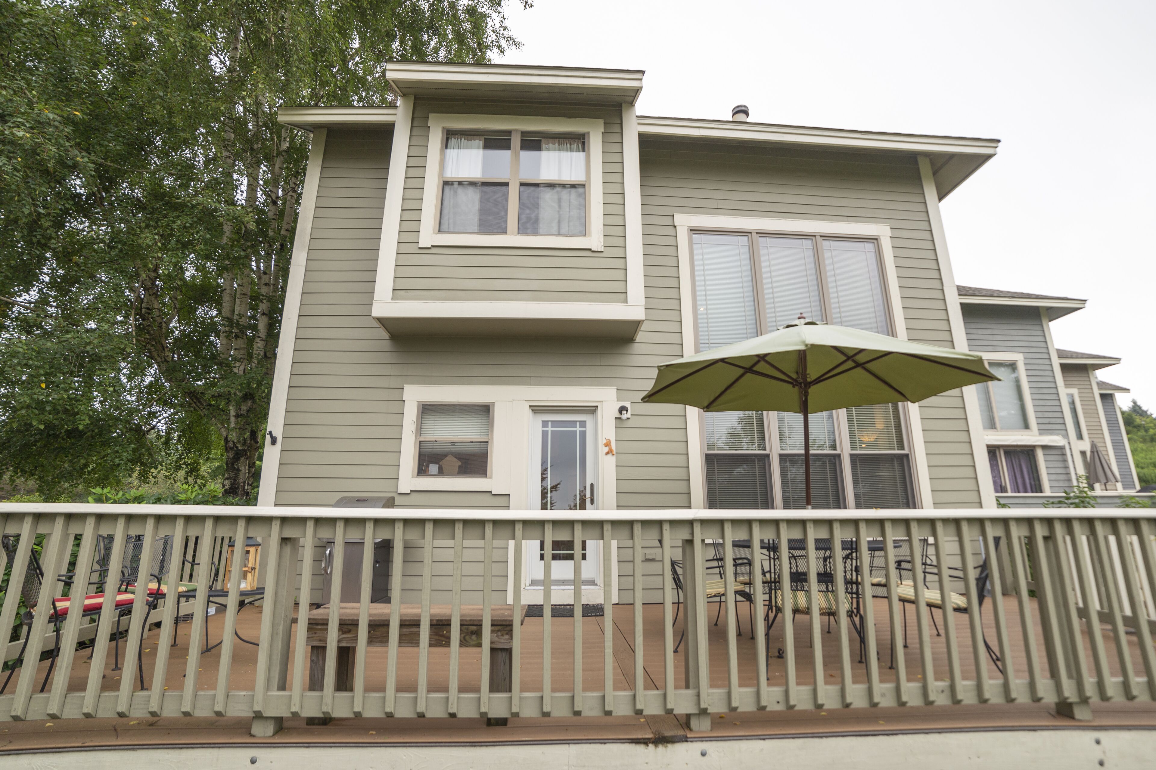 Une maison à deux étages dotée d’un patio couvert.