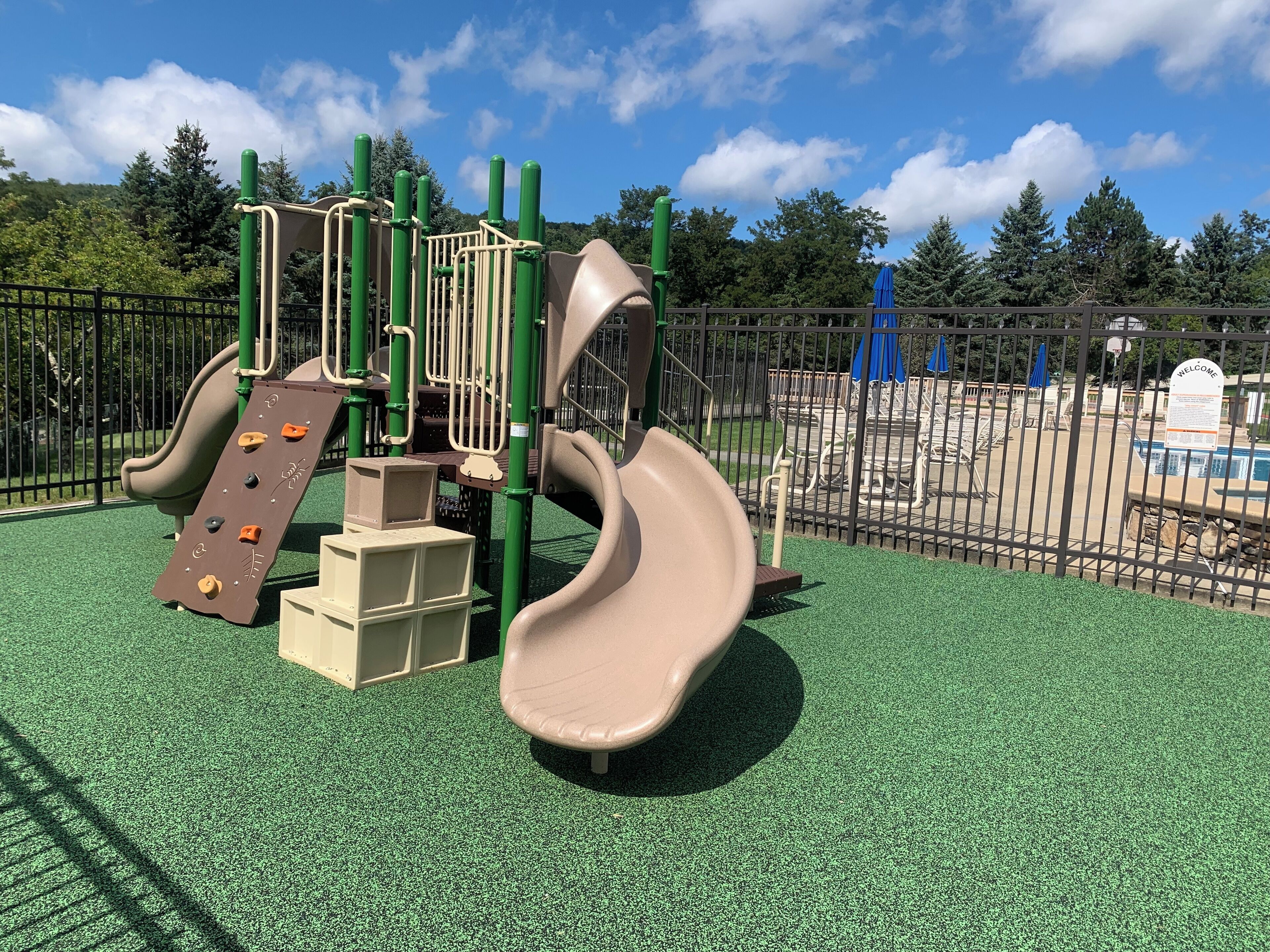 Une aire de jeux avec un toboggan et des structures d’escalade.