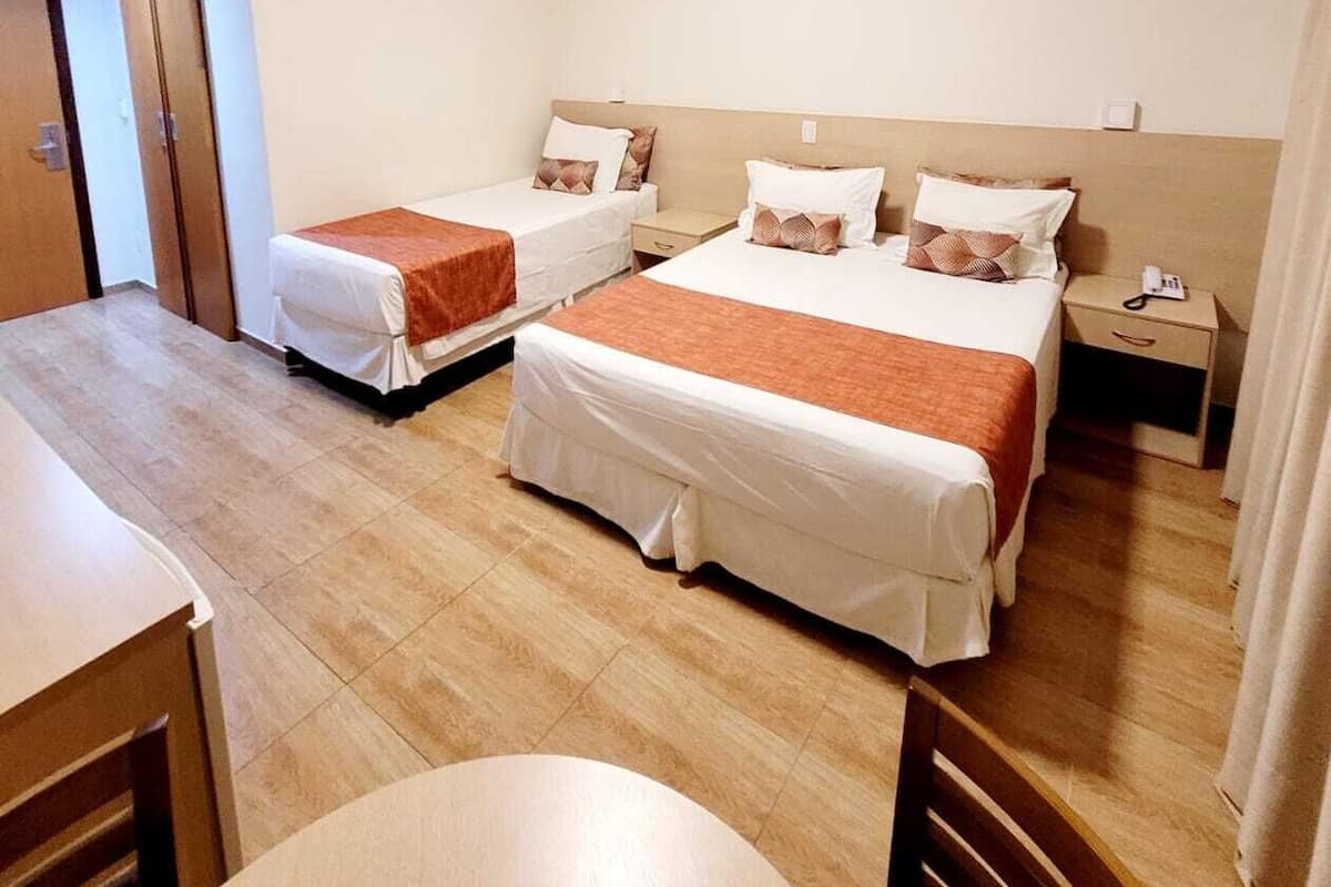 Une chambre d’hôtel avec deux lits simples, une petite table et une chaise.