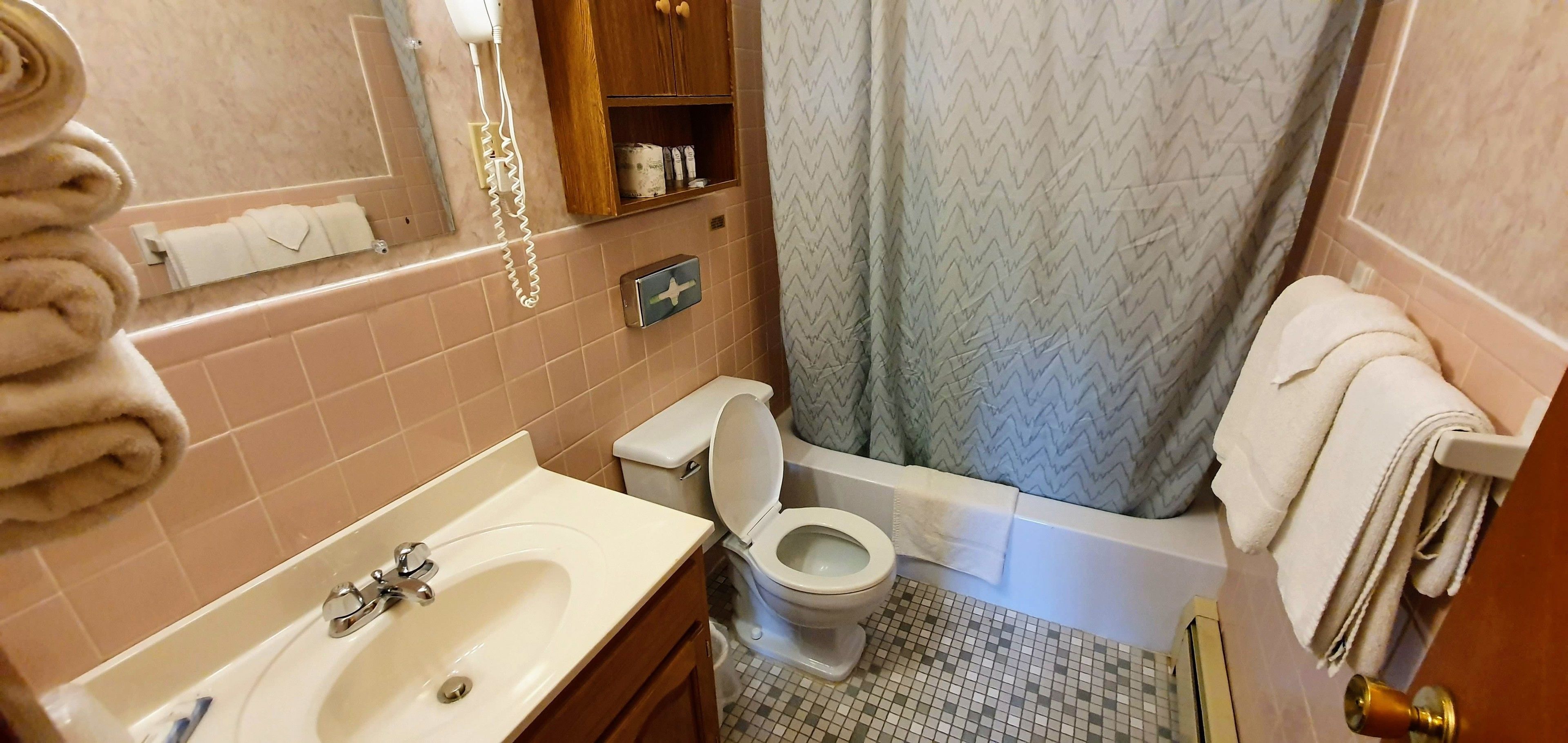 A bathroom with a sink, toilet, and bathtub.
